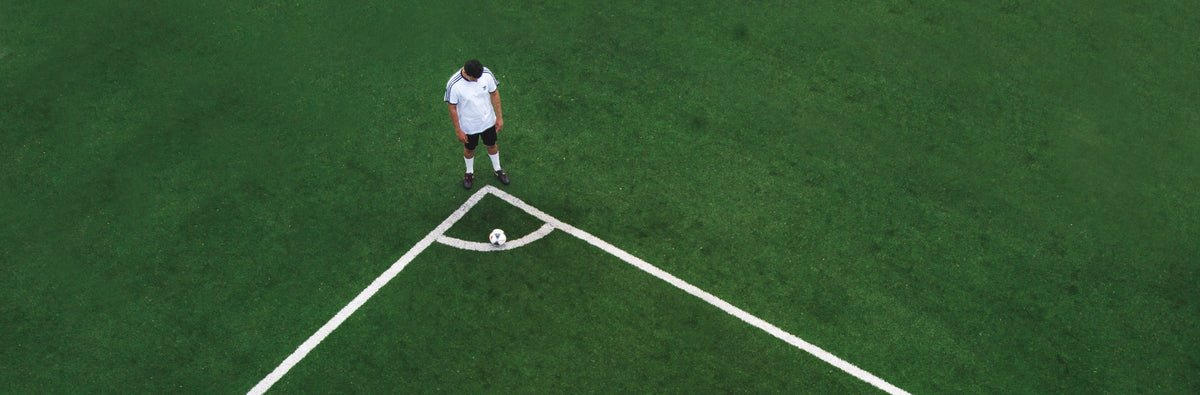 Football player preparing a corner kick on a sports field